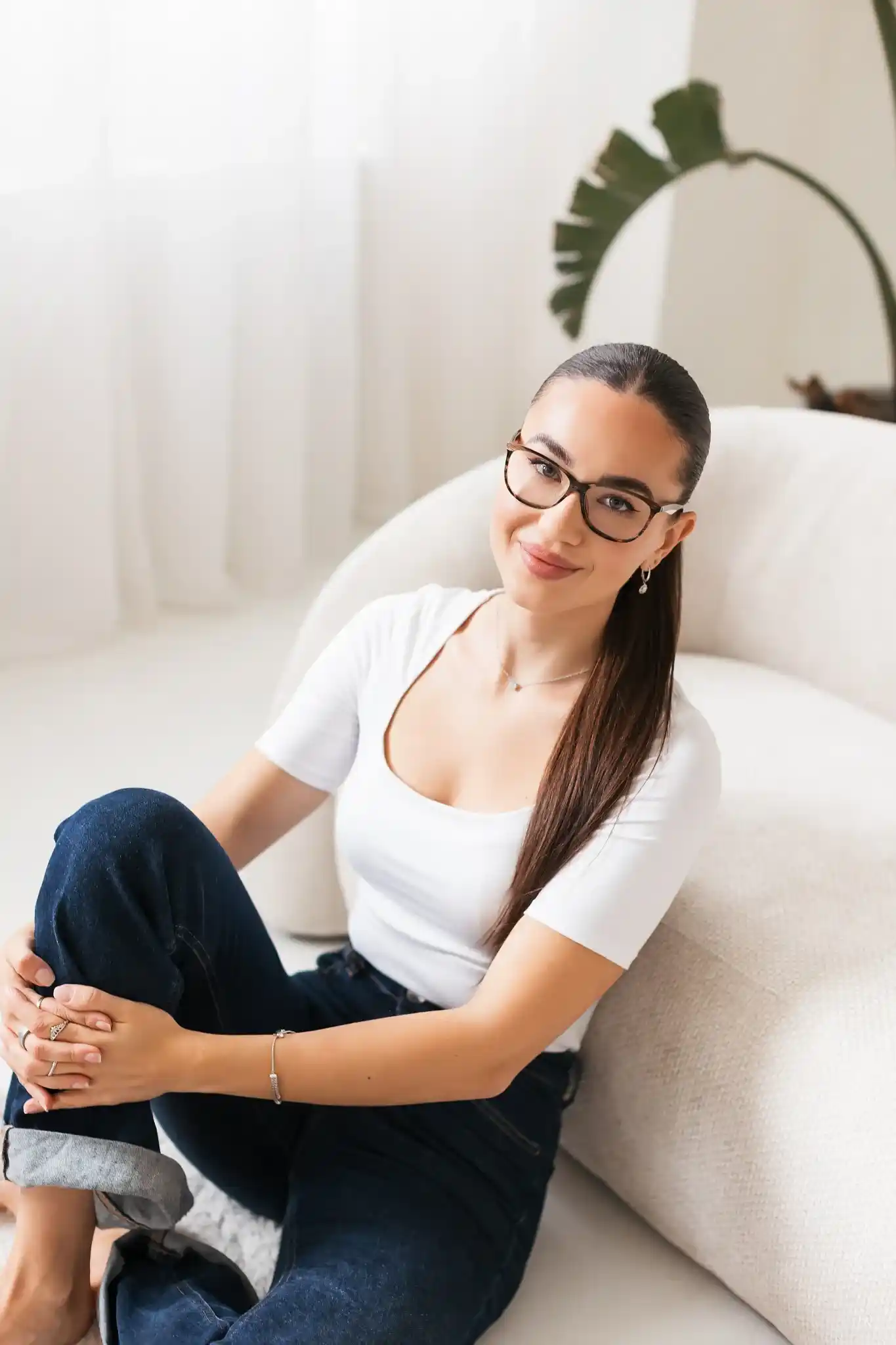 Erika smiling on a white sofa